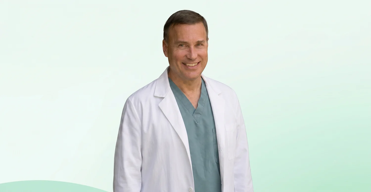 Dr. Jerry Hric smiling in his white coat